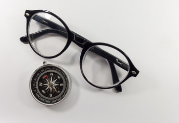 Glasses and black compass on a white background.