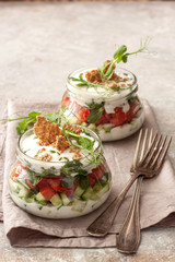 Fresh vegetable salad in jars with yogurt dressing