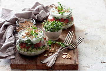 Fresh vegetable salad in jars with yogurt dressing