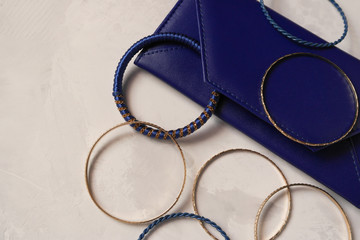 Blue clutch bag on a gray background with bracelets
