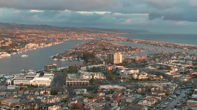 Cinematic urban aerial view of Newport Beach city, Lido Isle, Balboa Peninsula and harbor in Orange County in California.