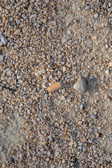 cigarette butt lies on gravel