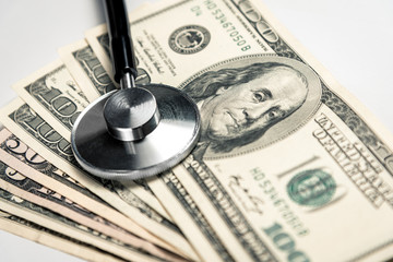 Stethoscope on a background of money - a business concept in medicine, a bribe to a doctor. Horizontal frame