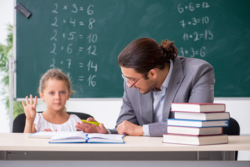 Teacher with young girl in the classroom