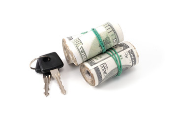 a folded wad of money with a rubber band and keys next to it
