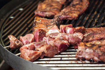 Street food background. Grilled pork ribs on the grill. Marinated pork spare ribs. Street market. Fresh grilled meat. Street festival.