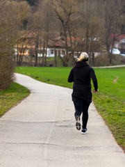 Fototapeta premium Blonde woman running in a park