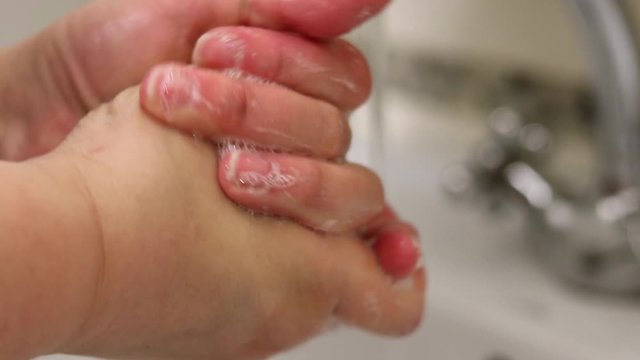 A woman uses soap and washes her hands under a faucet. Prevention of viruses, Coronovirus. Hygiene concept hand detail. Purity.