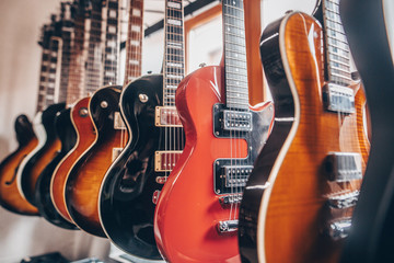 Close up of professional electric guitar in a row in instrument shop, instrumental concept - obrazy, fototapety, plakaty
