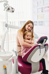 Little girl visiting dentist in clinic with her mom. Conception of stomatology