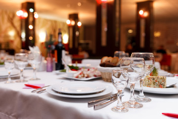Restaurant tables set for celebration.  Many food on the festive table