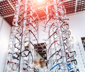 Eyeglasses shop. Stand with glasses in the store of optics. View from below on glasses.