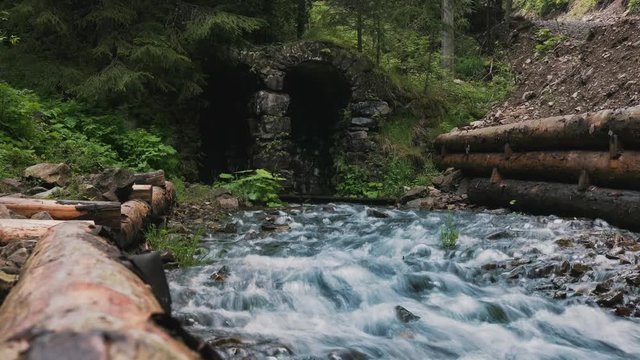 Stone arches through which a stream flows. Timelapse