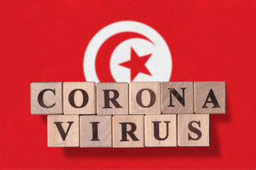 Flag of Tunisia with wooden cubes spelling coronavirus on it. 2019 - 2020 Novel Coronavirus (2019-nCoV) concept, for an outbreak occurs in Tunisia.