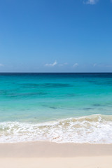 Fototapeta na wymiar Looking out over a turquoise ocean with a blue sky overhead, on the Caribbean island of Barbados