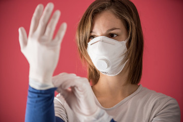 nurse with molded mask puts on surgical gloves to prevent coronavirus infections and prevent the spread of the world pandemic