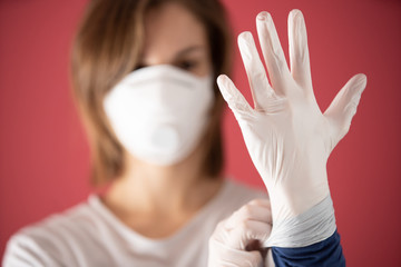 nurse with molded mask puts on surgical gloves to prevent coronavirus infections and prevent the spread of the world pandemic