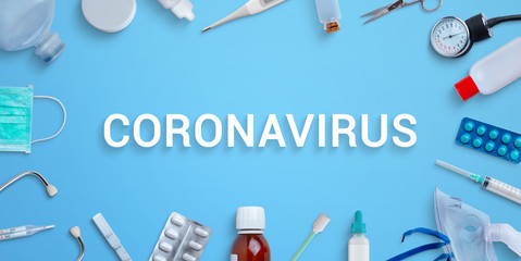 Coronavirus text on blue desk surrounded by medical equipment and medicines