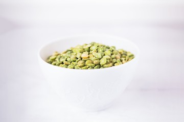 Dry split light green peas in a white cup