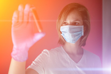 nurse wearing a mask, analyzes test tube of blood infected by coronavirus, generated in china, widespread in Italy and also arrived in the us with the risk of a 2019-ncov flu pandemic and deaths 