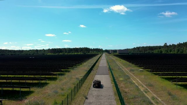 Drone footage of vintage car driving through solar power station build on former airport field in Templin, Germany