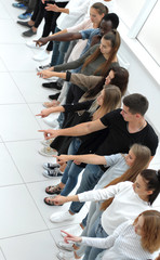 Fototapeta premium diverse young people standing in a row and pointing to a copy of the space