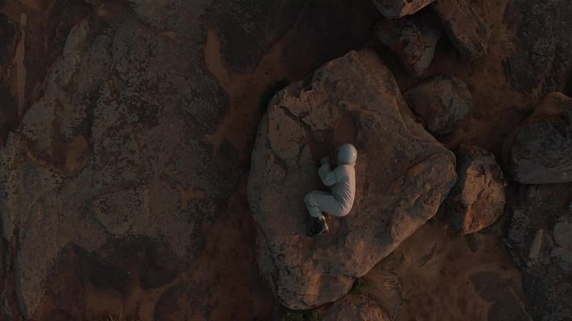 Top view of a lone astronaut on Mars. The astronaut lies on the surface of the planet Mars. Astronaut on the red planet.