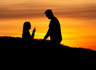 Fototapeta na wymiar Lovers couple in sunset time in nature shilouette