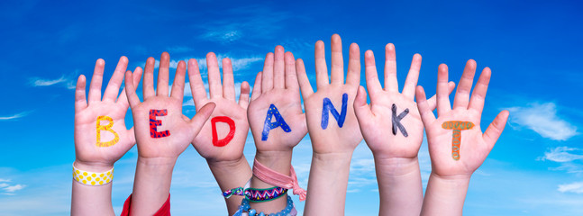 Children Hands Building Colorful Dutch Word Bedankt Means Thank You. Blue Sky As Background