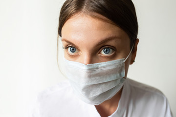 Close up of a female nurse putting on a mask to protect from airborne respiratory diseases such as the flu, coronavirus, ebola, TB, etc copyspace