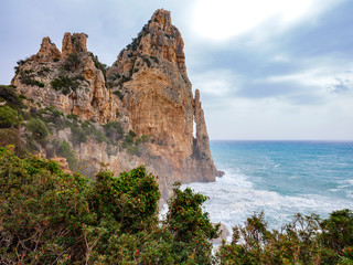 Fototapeta na wymiar Pedra Longa, an impressive limestone cliff in the beautiful region of Ogliastra, Sardinia. It is an natural monument, reachable through a small paved road or a coastal path.