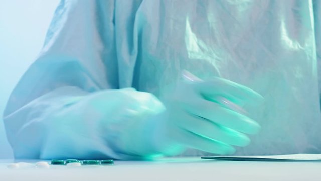 COVID-19 pandemic. Medical diagnosis. Doctor hand in protective glove writing prescription.