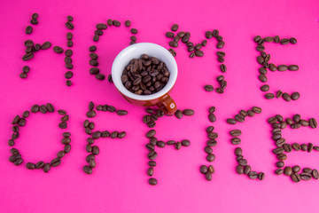 Home office made of coffee beans laid on a pink background