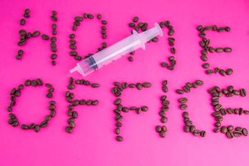 Home office made of coffee beans laid on a pink background