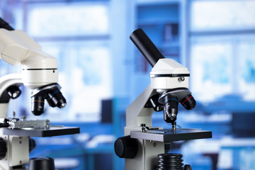 Modern scientific laboratory interior. Reaserch station with microscopes on the glass table.