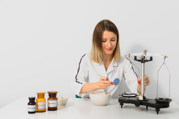 Professional pharmacist grinding a medical preparation using a mortar and pestle, pharmacy and medicine concept.