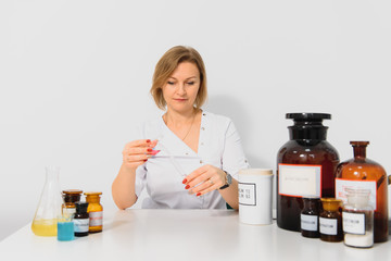 Professional pharmacist grinding a medical preparation using a mortar and pestle, pharmacy and medicine concept.