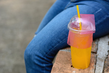 Young girl wearing ripped jeans and orange juice