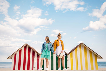 Two friends chatting calmly about their things, lies resting in some beach huts on a very colorful afternoon