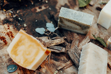 Various handmade natural soaps on a vintage wooden table with decoration
