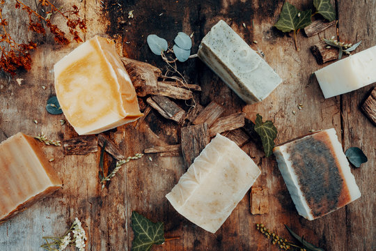 Various handmade natural soaps on a vintage wooden table with decoration