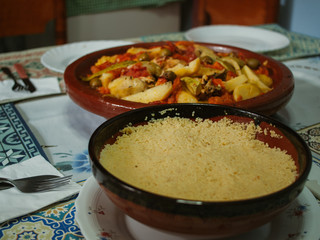 Tajine open on a table, next to couscous