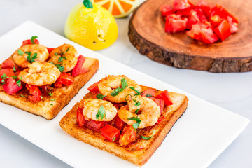 Shrimp Toast on White Platter Top View Food Photo. Toast with Shrimp, Tomatoes, Parsley, Horizontal High Angle Stock Photo.