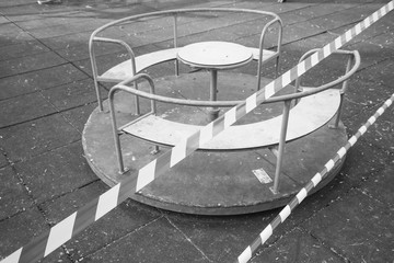 No entry barrier tape in front of an abandoned carousel, due to the quarantine restrictions activated to combat the Coronavirus pandemic.