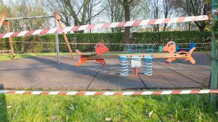 No entry barrier tape in a playground, due to the quarantine restrictions activated to combat the Coronavirus pandemic