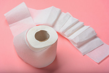 Tissue or toilet paper roll on pink background with copy space for wiping clean.