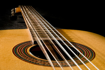 Classical guitar with vibrating strings on a black   background - Powered by Adobe