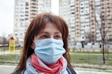 Woman wearing hygienic mask to prevent the Coronavirus. People in masks The outbreak of Novel Corona virus (2019-nCoV) in Europe. Concept of coronavirus quarantine. Air pollution