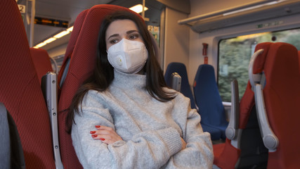 Pandemic, a woman in a protective mask rides a subway train.