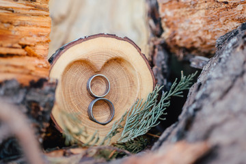 Fototapeta premium Wedding Ring symbol of love and human relationships on wood bowl